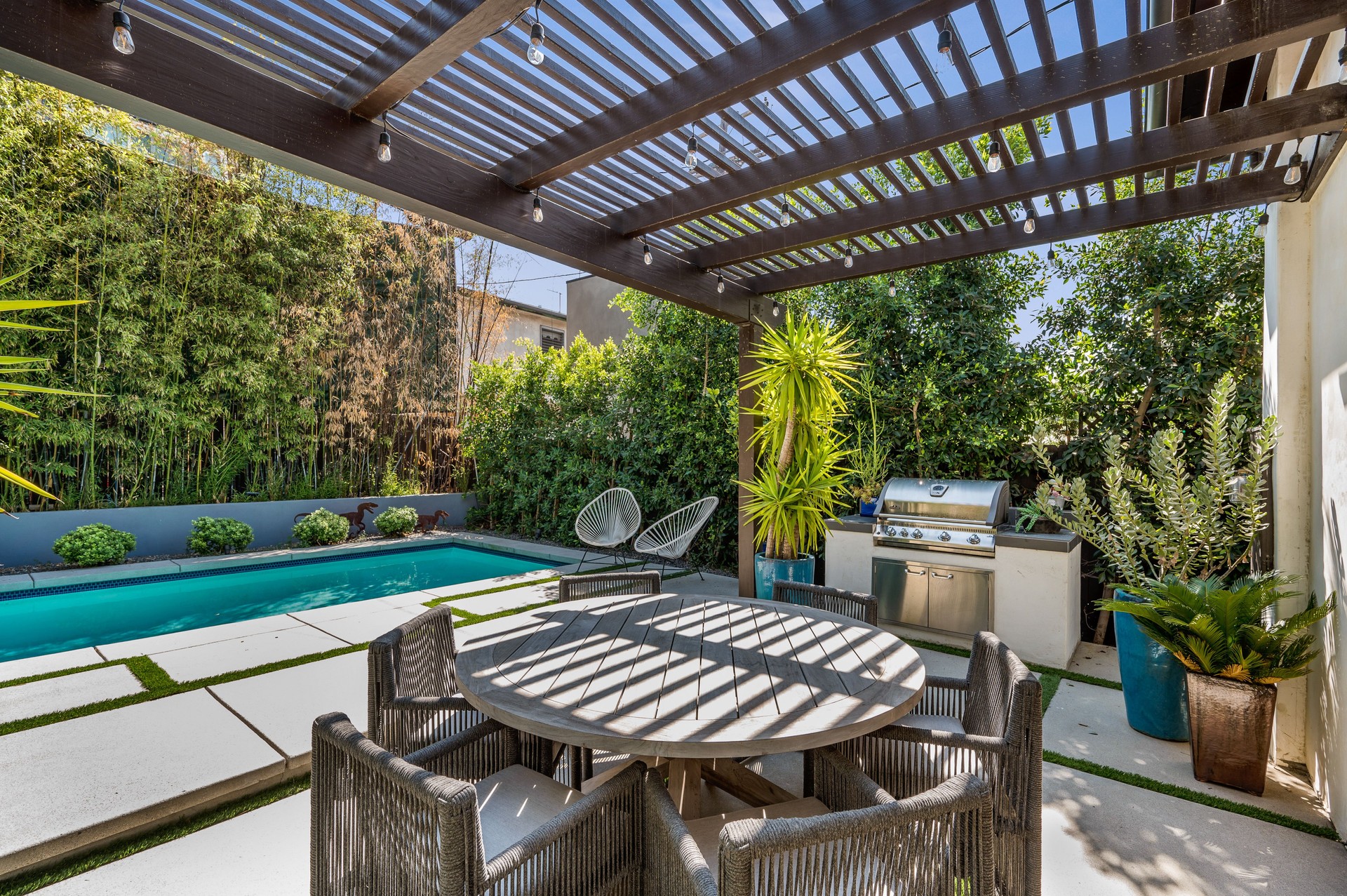 patio with table and chairs on it near a swimming pool